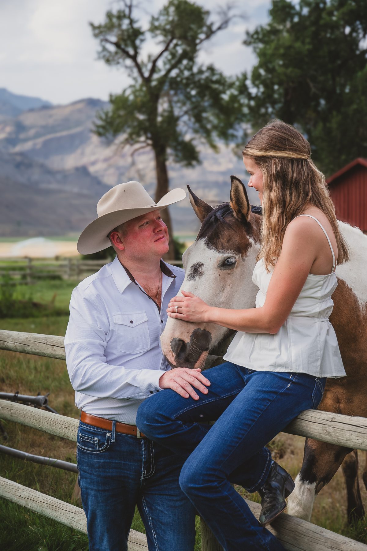 Mariah and Gabe with their horse at the ranch fence